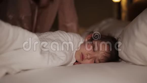 醒来的女人在床上笑着妈妈来到熟睡的孩子身边视频的预览图