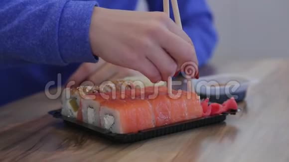 在日本餐馆里用筷子吃寿司的亲密少女视频的预览图