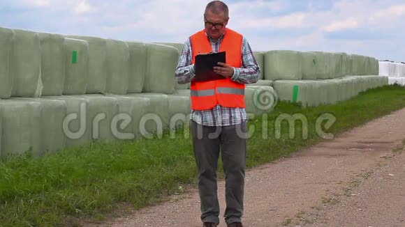 农民在干草堆附近的农村公路上写作和行走视频的预览图