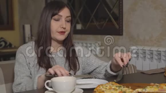 披萨饼在咖啡馆吃披萨的年轻女人视频的预览图