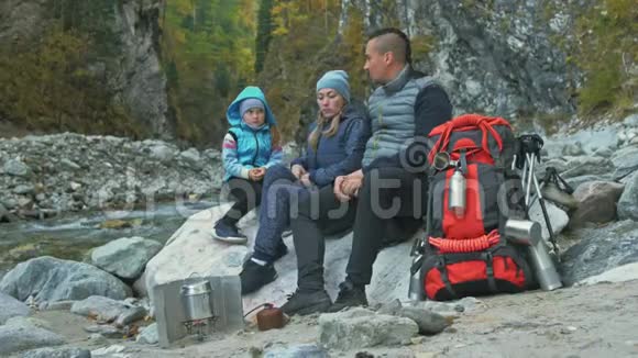游客在徒步旅行后休息家庭旅行人的环境由山河溪组成父母和孩子走路视频的预览图