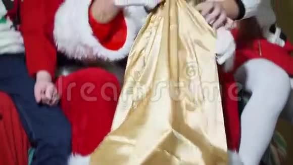 一个男孩和一个女孩的特写从圣诞老人的包里拿出礼物视频的预览图