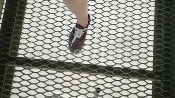 女孩正带着金属格子沿着桥走注意穿红色运动鞋的腿视频的预览图