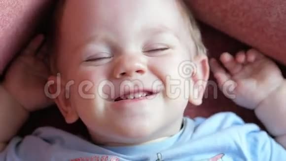 一个2岁有魅力的男孩正在看相机和玩面部表情他微笑尖叫闭上眼睛视频的预览图