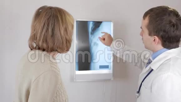 一位年轻的男医生向一位老年妇女展示了X光检查的结果肋骨有问题他说的是视频的预览图