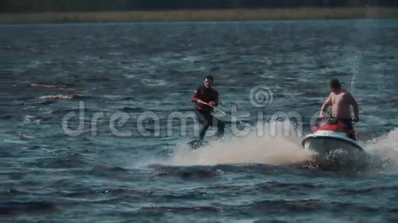 运动员穿着救生衣在湖上骑着尾板手里拿着绳子绑在喷气式滑雪板上视频的预览图