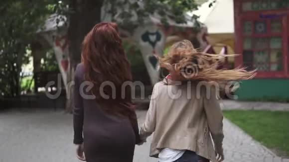 红头发的女孩跑开了摄像机后面的景色女朋友在户外玩得很开心慢动作视频的预览图