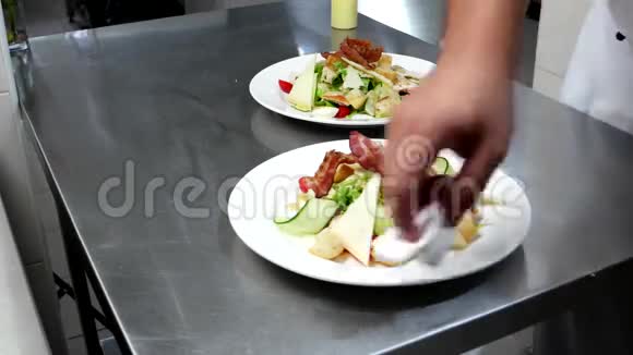 凯撒沙拉是在专业的厨房厨师在为餐厅的顾客服务之前倒入酱汁的菜肴一份带有沙拉的沙拉视频的预览图