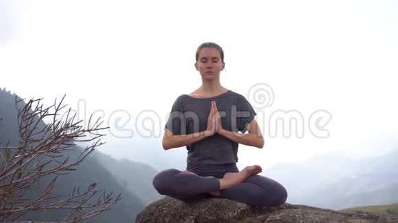 越南萨帕山崖上坐坐冥想姿势的瑜伽女人视频的预览图