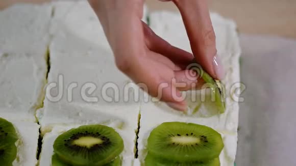 女人手工装饰蛋糕猕猴桃视频的预览图