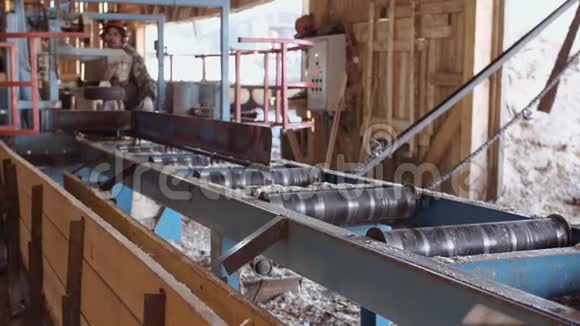 木匠在工业锯工作台上劈树日志视频的预览图