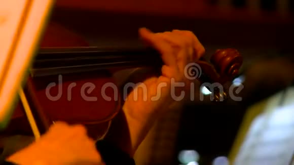 交响乐团演出期间特写小提琴手在音乐会上演奏视频的预览图