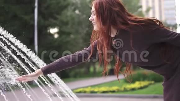 红头发的女孩在喷水慢动作视频的预览图