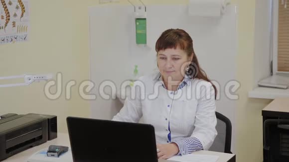 一位在诊所电脑工作的老年医生视频的预览图