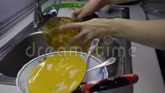 女人清洗和冲洗餐具视频的预览图