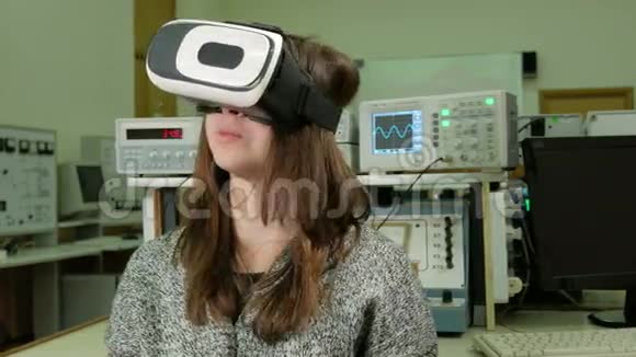 在大学物理实验室里戴虚拟现实眼镜的年轻女学生她考虑了3D模型视频的预览图