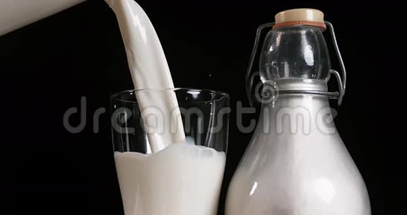 牛奶被倒入黑背景玻璃中视频的预览图