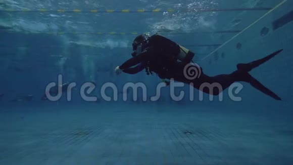 潜水员漂浮在游泳池的水下学习水肺潜水课程视频的预览图