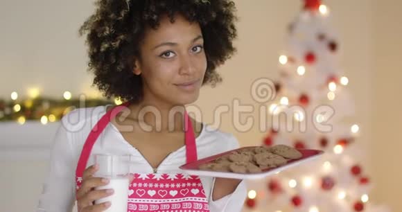 为圣诞老人准备牛奶和饼干的年轻快乐女人视频的预览图