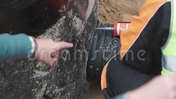 工人准备在缝黑色塑料管和混凝土孔上涂密封胶视频的预览图