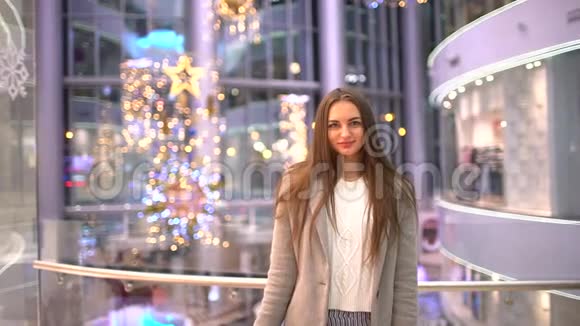 美丽的女人为圣诞节买礼物购物中心的买家手里拿着大的多色包裹圣诞节视频的预览图