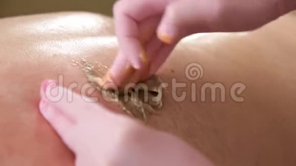 美容师在手套使男性背部与糖男性美容护理视频的预览图