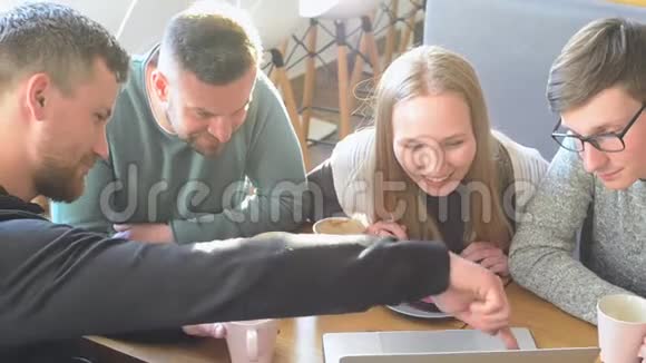一群快乐的朋友或同事在一家小咖啡馆里喝着咖啡笑着一起用电脑视频的预览图