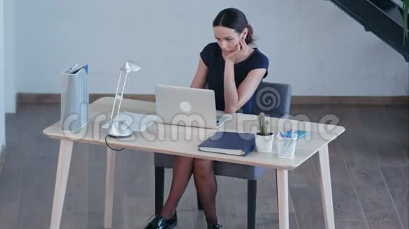 有魅力的商业女性在大型阁楼工作室使用笔记本电脑视频的预览图