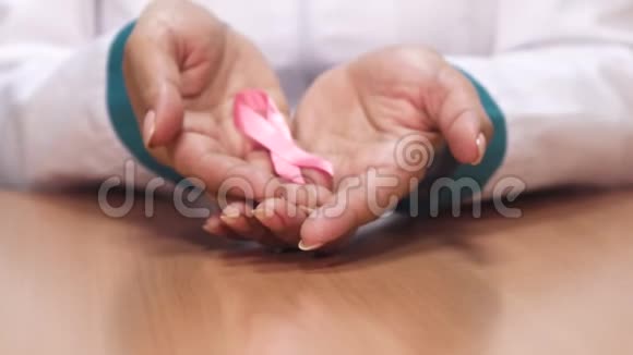 一位女医生举着粉红色的丝带为乳腺癌的认识服务视频的预览图