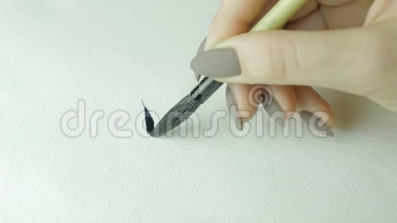 女人手写着中文象形文字女手握着毛笔书法汉字合上视频的预览图