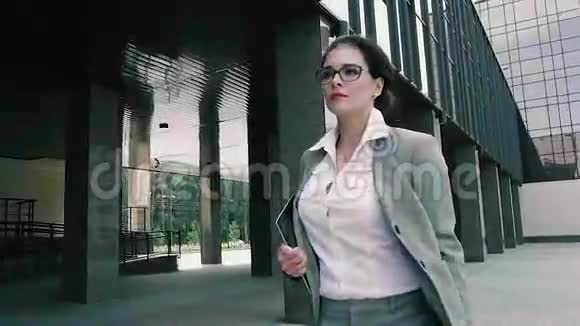 精明的商界女性走向办公楼视频的预览图
