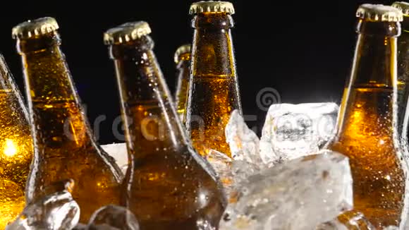 凝结水从啤酒中流出棕色的瓶子黑色背景关门视频的预览图