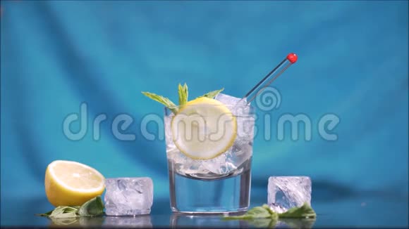 伏特加汤力加蓝色背景的黄色柠檬片视频的预览图