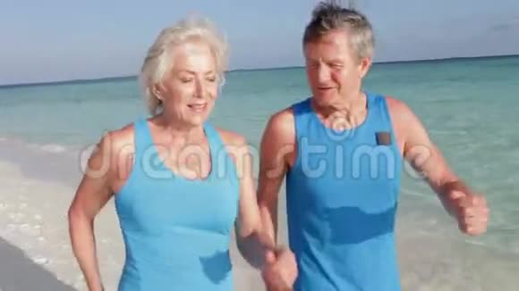 高级夫妇在美丽的海滩上散步视频的预览图