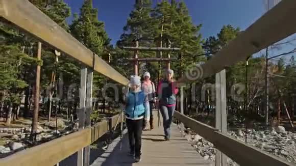 女人在大自然中行走北欧女孩和孩子使用跋涉棒和北欧杆背包人们在散步视频的预览图