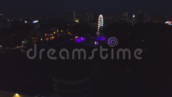 晚上在城市公园里的摩天轮剪辑夜间摩天轮发光的俯视图视频的预览图