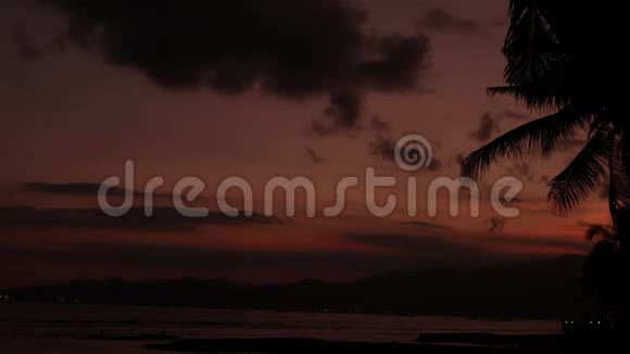 日出覆盖热带岛屿海滩和棕榈树巴厘岛视频的预览图