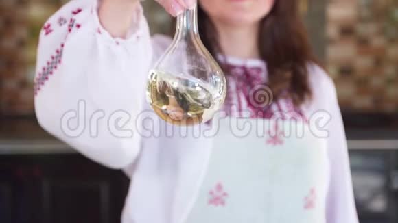 在准备沙拉之前一个女孩在烧瓶里搅拌橄榄油慢动作视频的预览图