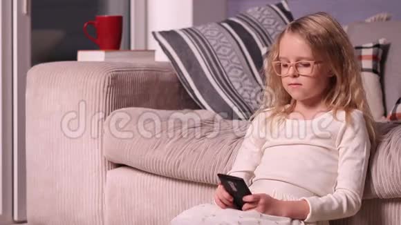 漂亮的小女孩在玩智能手机视频的预览图