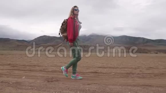 带背包的游客在山上的肖像女孩旅行者在恶劣的天气里行走在山区视频的预览图