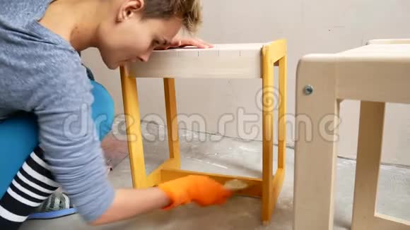 一个女孩在画椅子用你自己的手在公寓里修理视频的预览图
