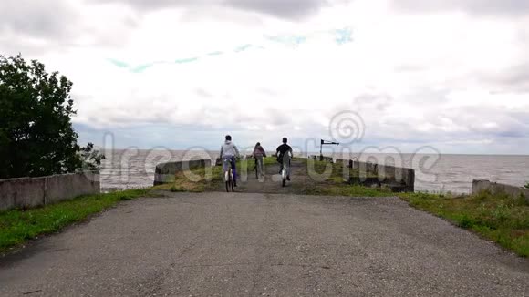 年轻的运动员在两辆自行车我停在湖边码头在大风天气视频的预览图