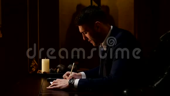 年轻人在桌子旁的一张纸上写字视频的预览图