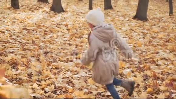 快乐的小女孩在秋天的公园里和妈妈玩视频的预览图