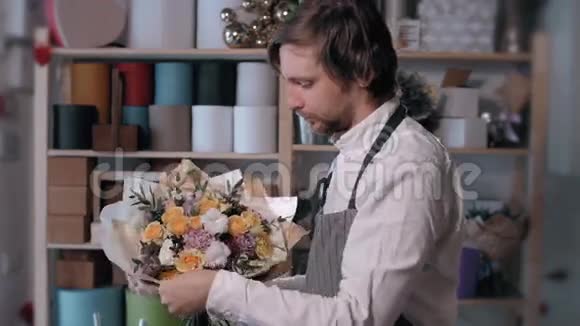 快乐微笑的花店老板在花店做一束人商业销售和花卉的概念玫瑰花束视频的预览图