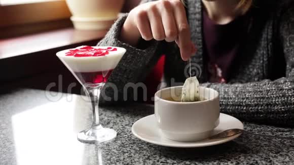 坐在咖啡馆里泡绿茶或红茶的女孩视频的预览图