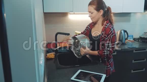 女孩在厨房砧板上洗碗女人在厨房做饭女孩在生活方式上洗了一把刀视频的预览图