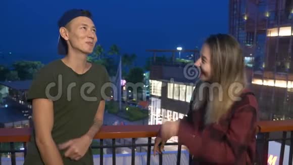 年轻漂亮的亚洲夫妇男人和女孩站在城市的街道上互相交谈视频的预览图