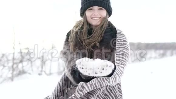 冬天女孩在镜头前吐雪微笑慢慢地视频的预览图