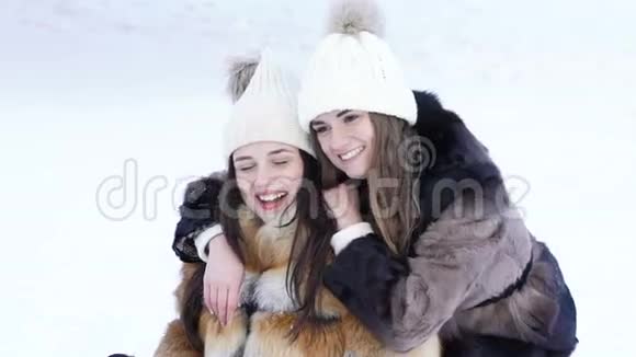 两个漂亮的女孩在冬天公园摆姿势自拍慢慢地视频的预览图